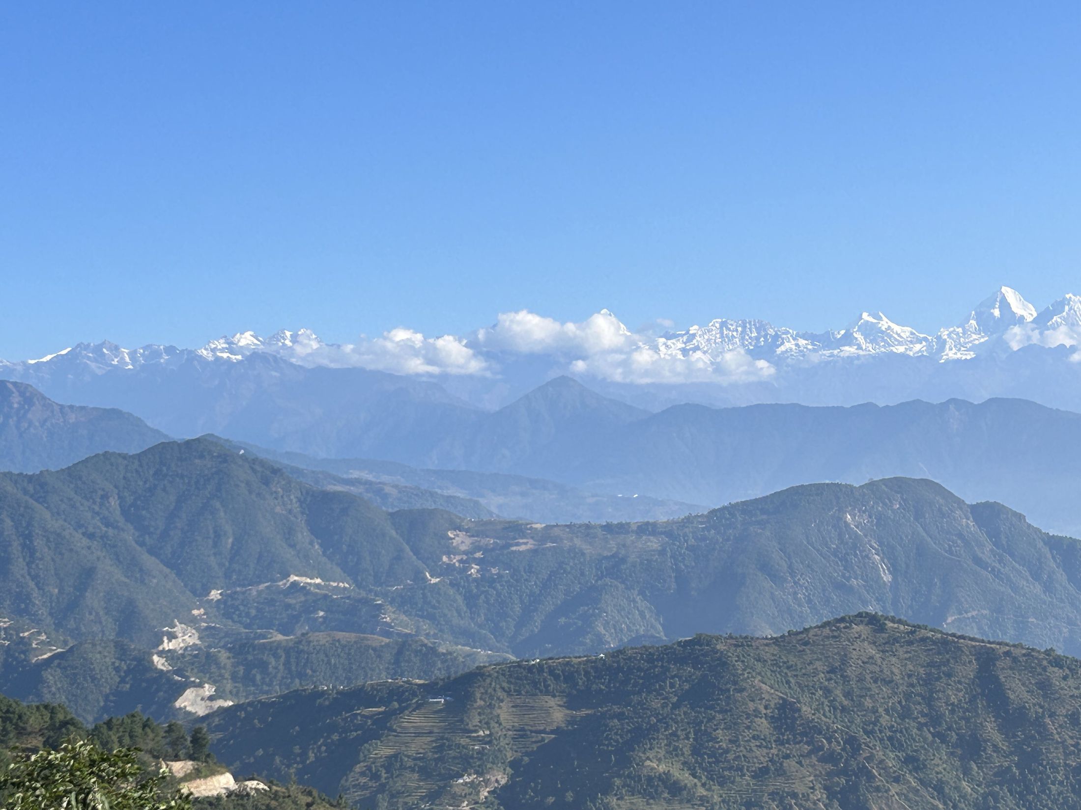 Snow peaks of the Himalaya above blue ridgelines