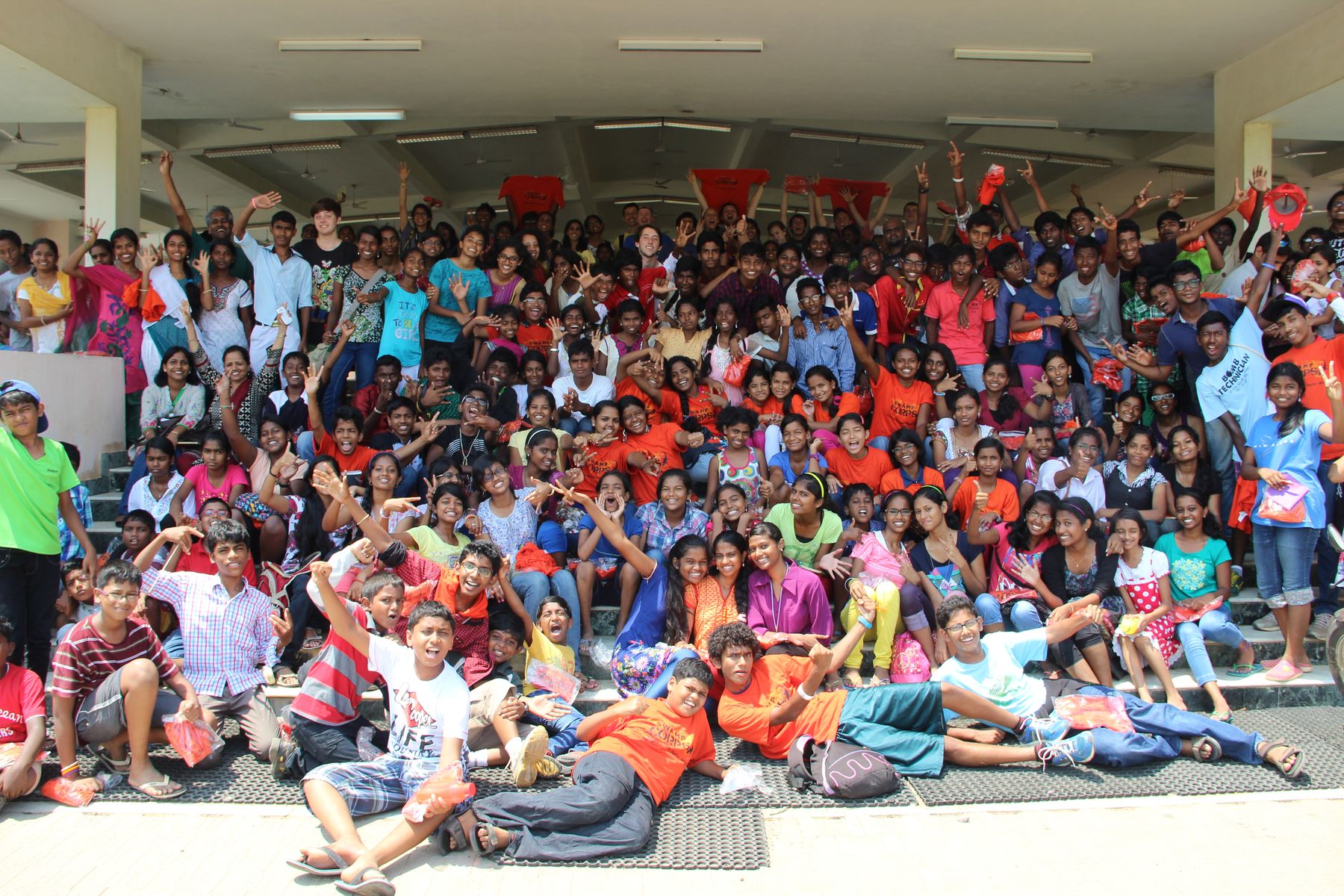 A whole camp cheering on a flight of steps, arms raised